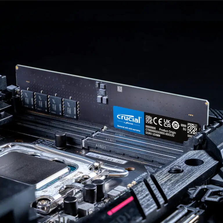 A close-up of a Crucial 32GB 5600MHz DDR5 Desktop Memory module installed on a computer motherboard, showing detailed chips and label information.